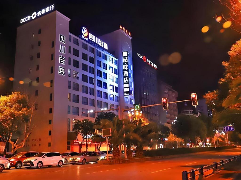 a large building with cars parked in a city at night at James Joyce Coffetel Guangyuan High-Speed Railway Station Dongba Municipal Government in Guangyuan