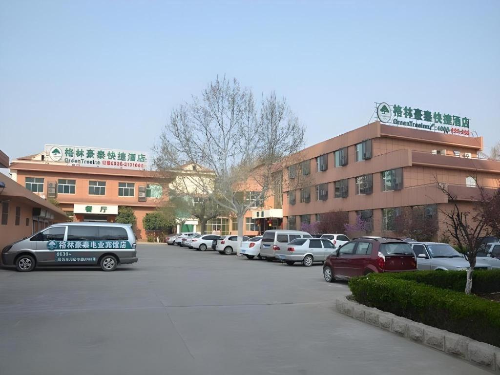 a parking lot with cars parked in front of a building at GreenTree Inn WeiFang QingZhou Middle HaiDai Road Electric Power Shell in Weifang
