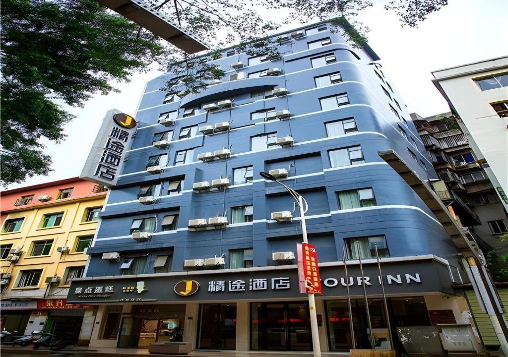 un bâtiment bleu dans une rue de la ville avec un feu de circulation dans l'établissement JTOUR Inn Wuzhou Arcade City Sanzongfu, à Wuzhou