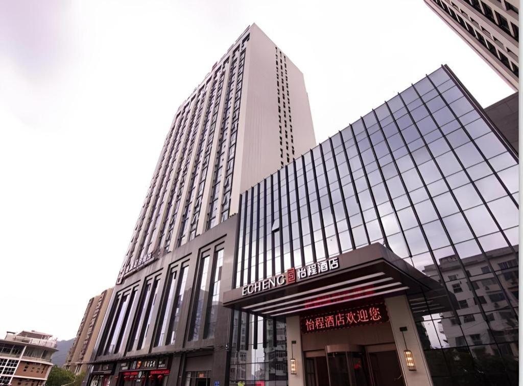 a large tall building with a sign in front of it at Echeng Hotel Sanming City Government RT-Mart in Sanming