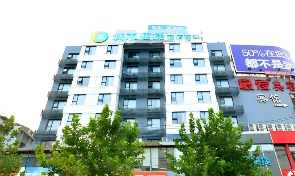 a tall white building with a sign on it at City Comfort Inn Wuhan Zhongnan Road Fujiaopo in Wuhan