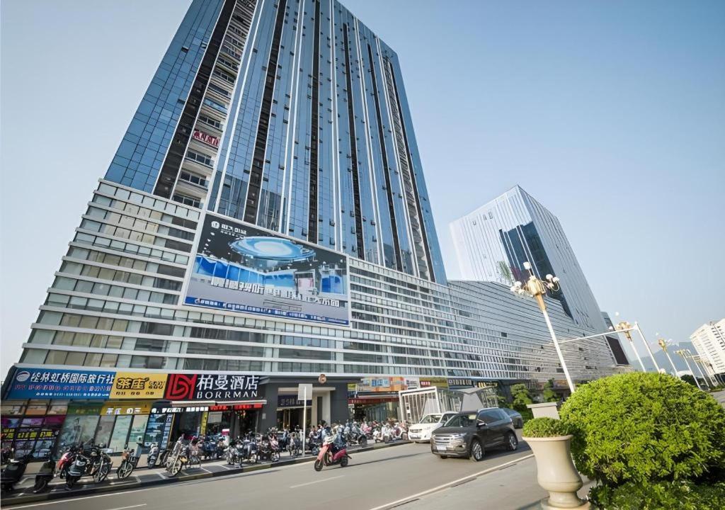 un grand bâtiment avec beaucoup de motos garées devant dans l'établissement Borrman Hotel Guilin High-speed Railway North Station Evergrande Plaza, à Guilin