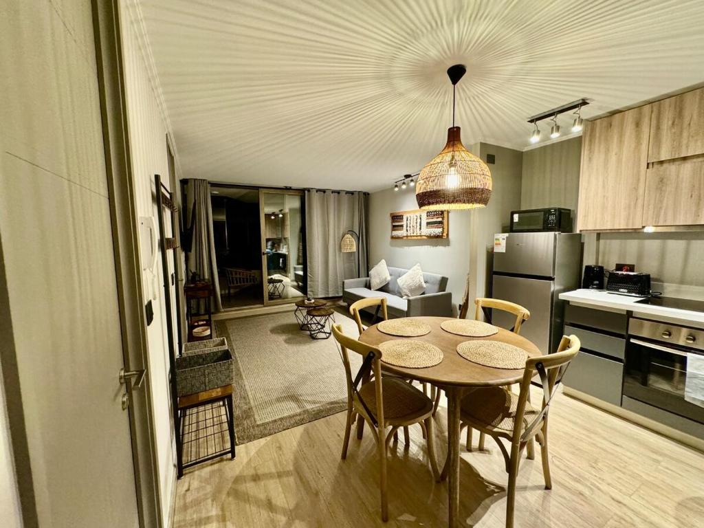 una cucina e una sala da pranzo con tavolo e sedie di Departamento Refugio Vista al Volcán Pucón a Pucón