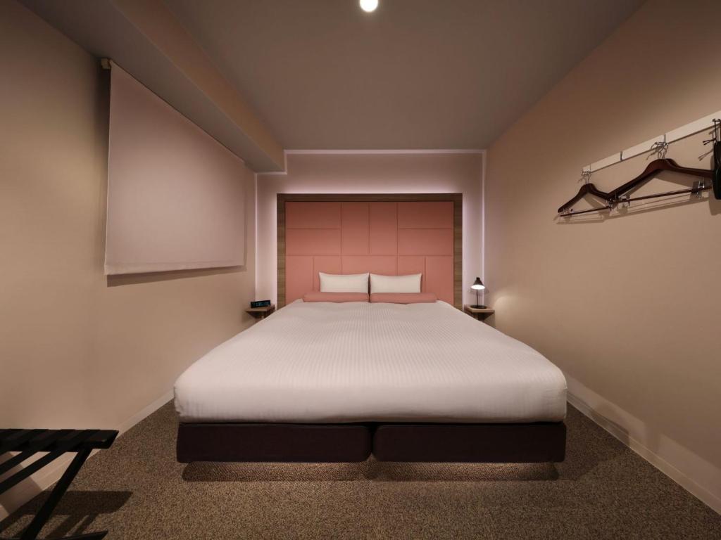 a bedroom with a large white bed in a room at Dotonbori Crystal Hotel - Vacation STAY 77453v in Osaka