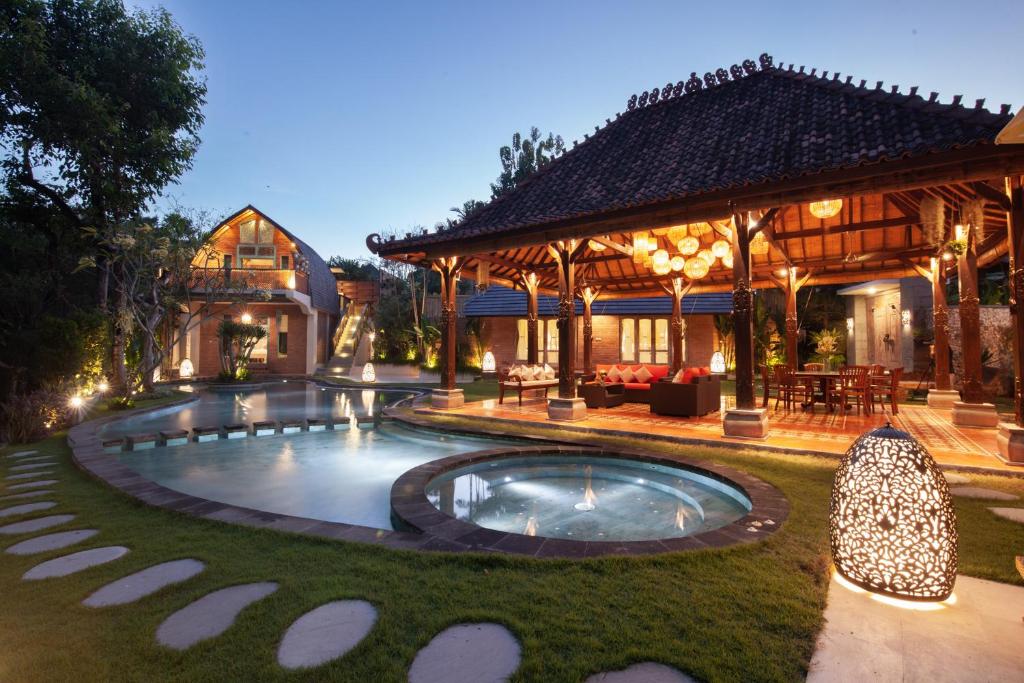 a house with a swimming pool in the yard at Sunset Paradise Villa Nusa Dua in Nusa Dua