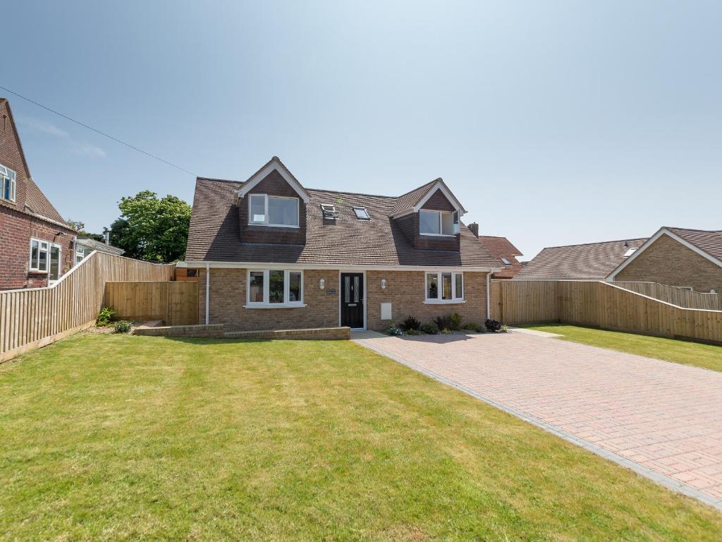 una casa de ladrillo con una cerca y un patio en Downs View, en Sandown