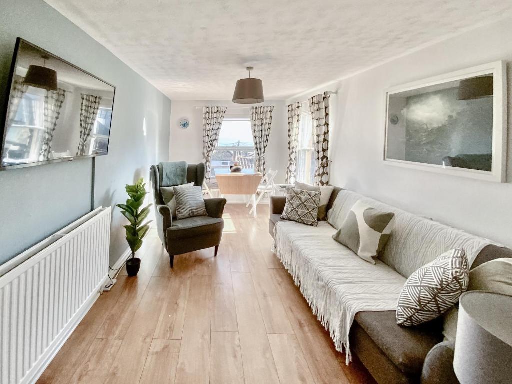 a living room with a couch and a chair at Corner View in Broadstairs