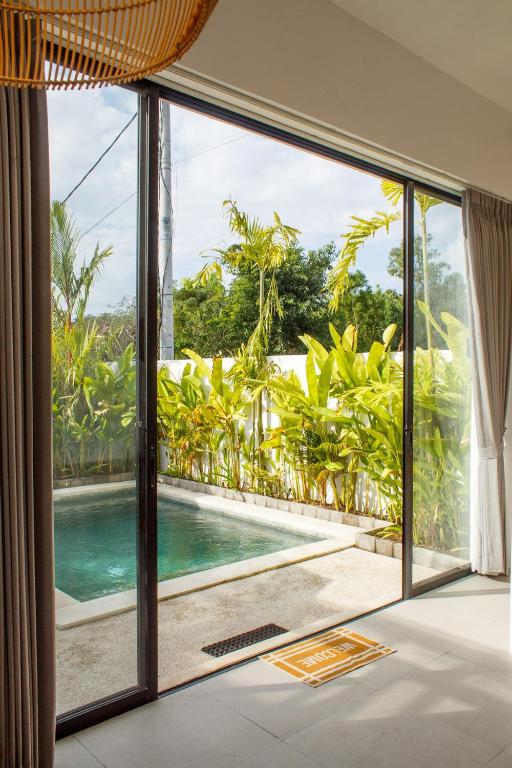 a room with a view of a pool seen through a window at Jaya Villas #1 in Uluwatu