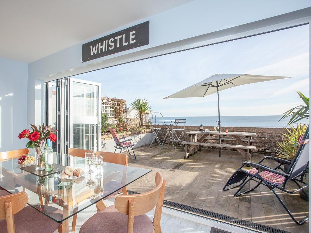 a dining room with a view of the ocean at Seaspray, Coastguard Cottages in Dawlish
