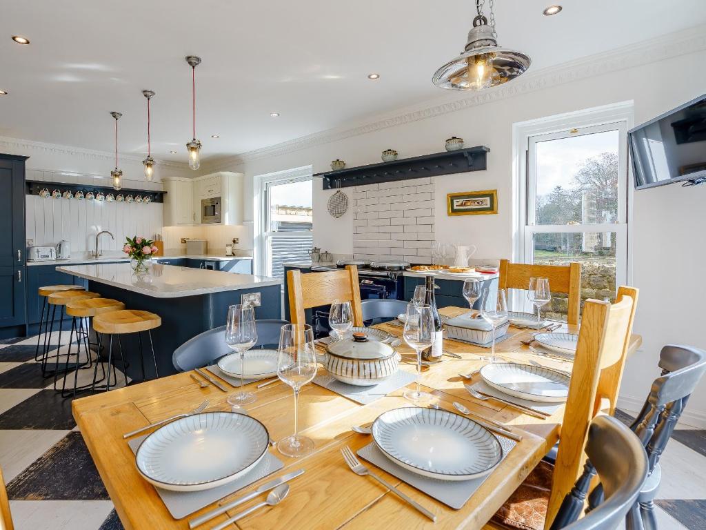 a dining room with a table with plates on it at Brookleigh Farm Cottage in Burley in Wharfedale