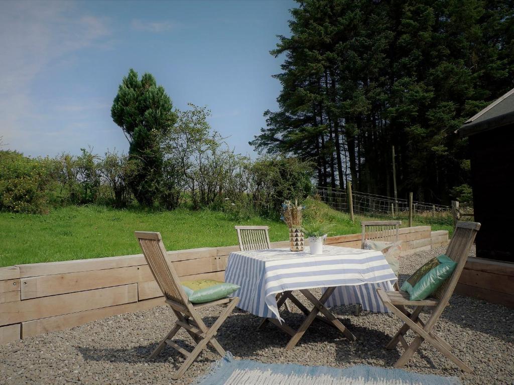 a table with two chairs and a table with a striped table cloth at Fern Forest House- Uk31047 in Portpatrick