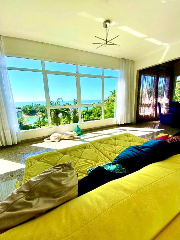 a large yellow bed in a room with a large window at Sonho do Moreno in Vila Velha