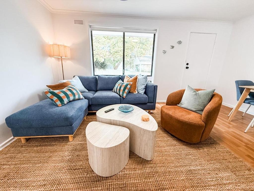 a living room with a blue couch and two chairs at Halloran 2 in Wagga Wagga