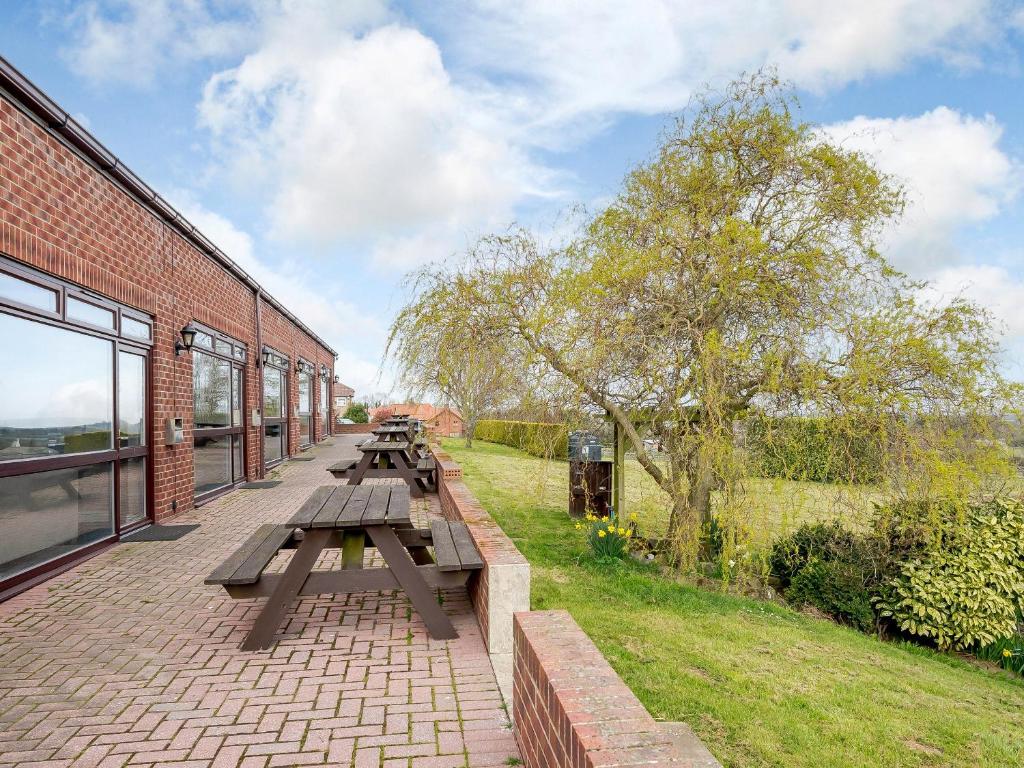 a group of picnic tables on a brick building at Cottage 8 - Uk38219 in Ashby cum Fenby