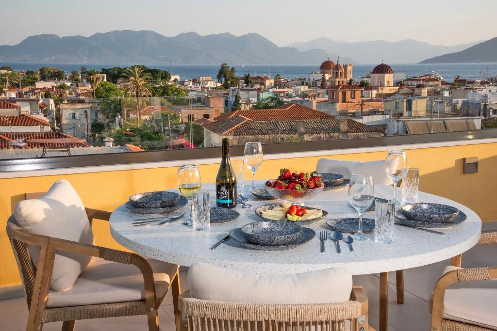 a table with food and wine on a balcony with a view at Grypes Deluxe Complex in Egina