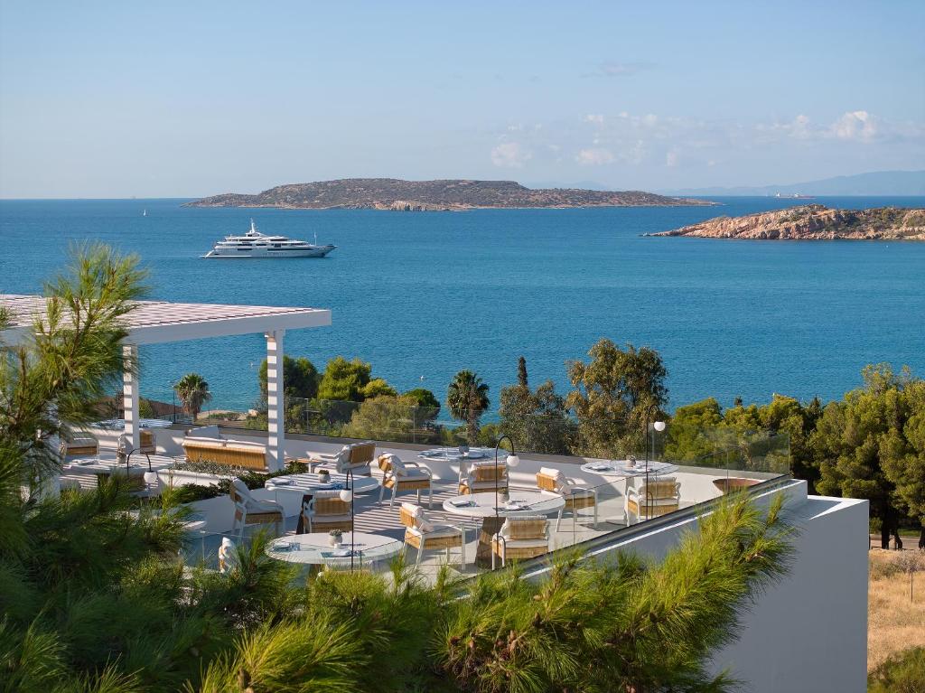a view of a resort with a cruise ship in the water at The Roc Club, A Grecotel Hotel to Live in Athens
