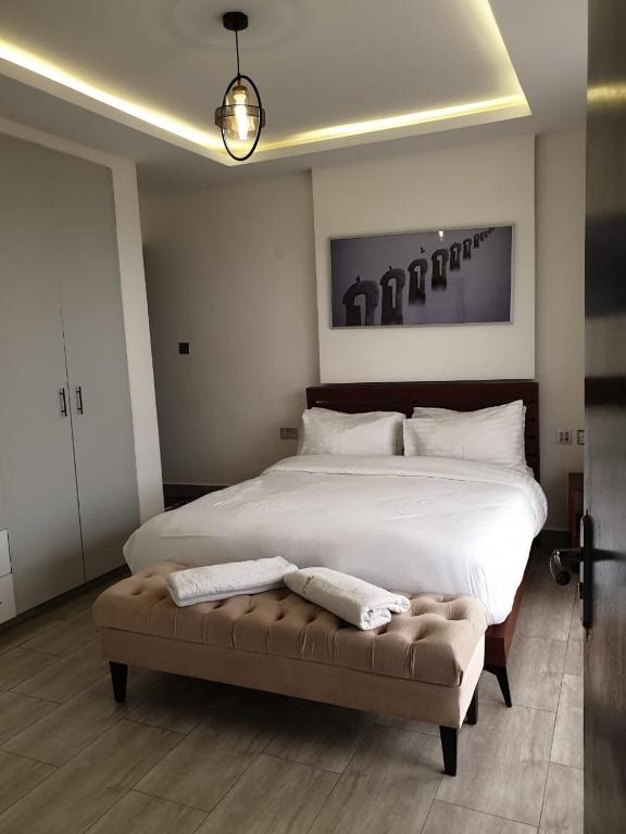 une chambre avec un grand lit blanc et un canapé dans l'établissement Blowsuites Furnished Apartment, à Lotus Island