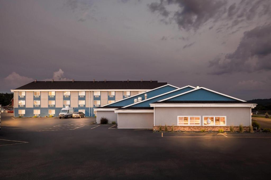 a large building with a parking lot in front of it at Super 8 by Wyndham Osseo WI in Osseo