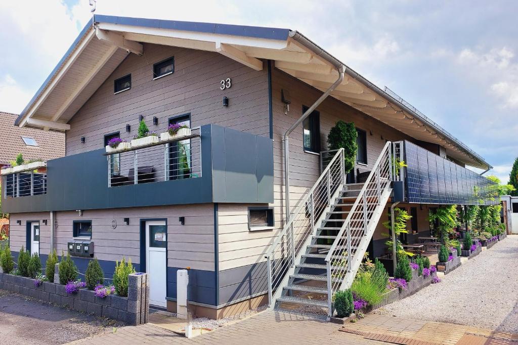 a house with a spiral staircase in front of it at APPARTEMENTHAUS "AM KORNFELD" - 10 Apartments, 40 Betten, Raucher-Balkon, Waschraum, Garten, Grillplatz, Tischtennis, Parkplatz in Lünen