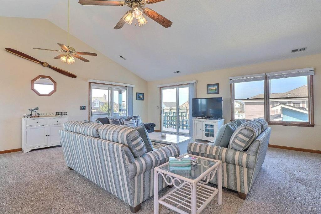 a living room with two chairs and a tv at 5042 - Beachside Hangar in Kill Devil Hills