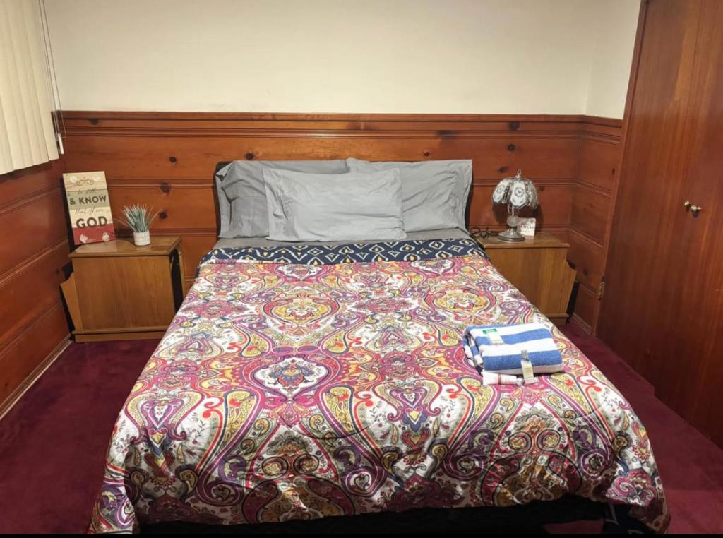 una cama con un edredón colorido y dos libros en ella en Room in Monterey Park CA, en Monterey Park