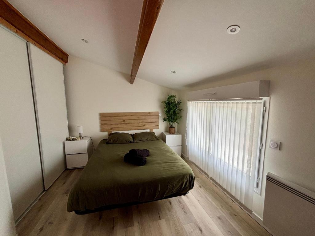 a bedroom with a bed and a large window at Les Flots de Barzan Appartement atypique avec vue mer in Barzan