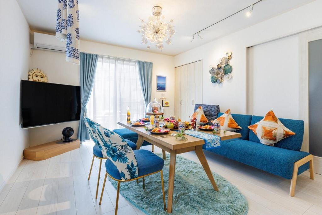 a living room with a blue couch and a table at おきなわワールドまで車で6分最大9名駐車場2台 hana ohana in Yaese