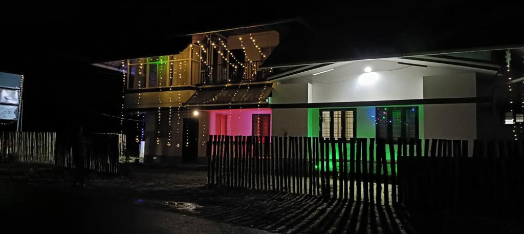 a building with colorful windows and a fence at night at Love shore homestay in Vagamon