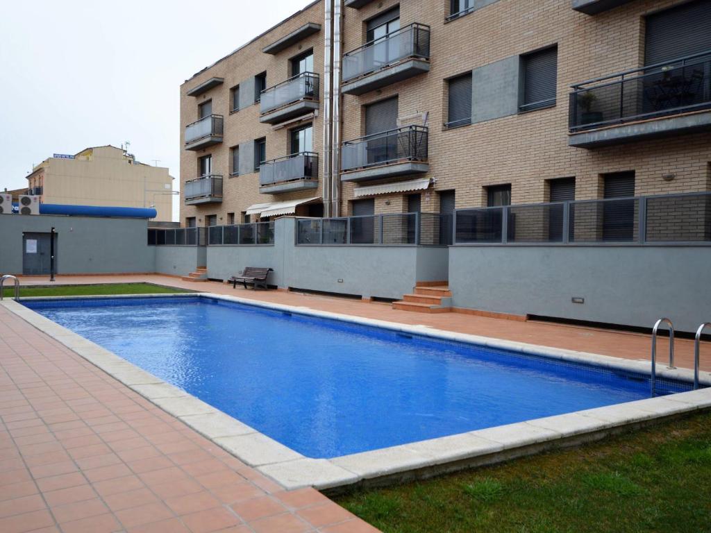 ein großer blauer Swimmingpool vor einem Gebäude in der Unterkunft Apto. céntrico en Sant Pere Pescador - Piscina, jardín, A/C, terraza grande, wifi - ES-89-88 in Sant Pere Pescador