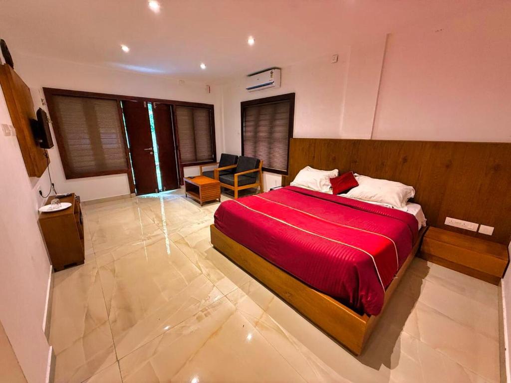 a bedroom with a bed with a red blanket at Casamia Garden in Batheri