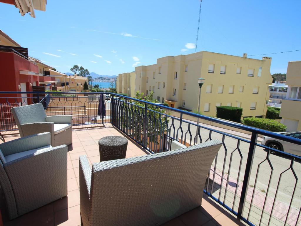 ein Balkon mit Stühlen und Blick auf die Stadt in der Unterkunft TRAMUNTANA - Casa amplia, moderna y muy bien equipada, situada en la zona de Grifeu - ES-228-144 in Llança