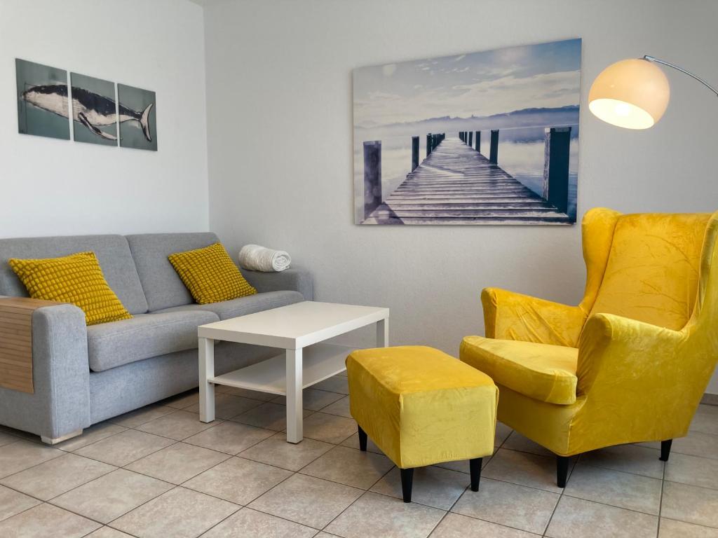 a living room with a couch and a chair at CUXKieker - Moderne Ferienwohnung mit Pep in Cuxhaven-Sahlenburg, WLAN, Parkplatz und Gartenblick, nah am Nordseestrand und Wernerwald in Cuxhaven