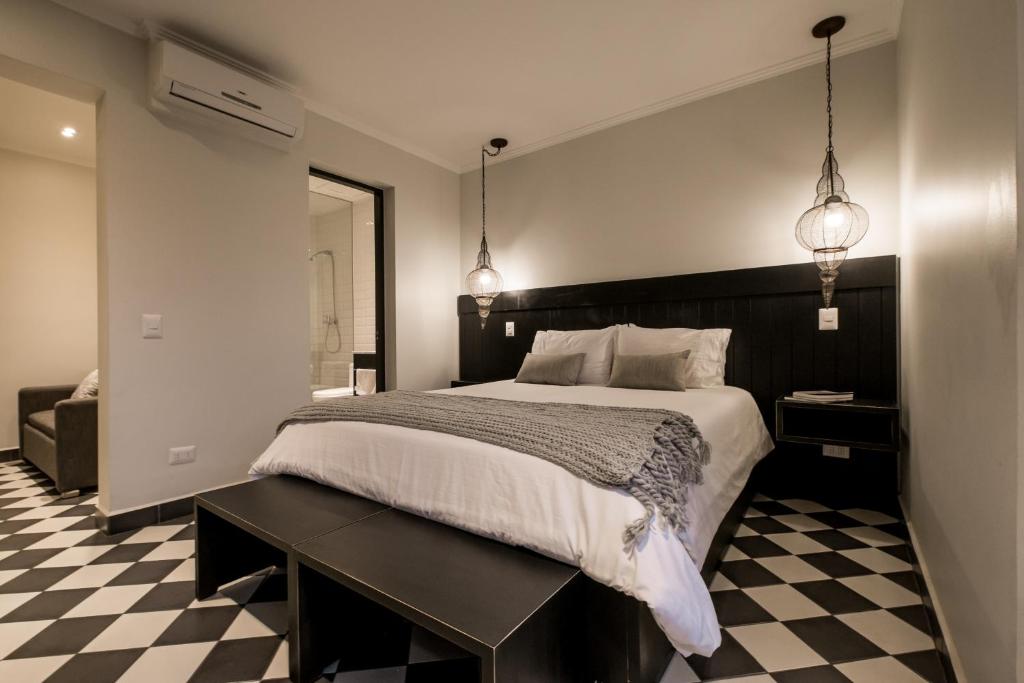 a bedroom with a large bed and a checkered floor at Apart Hotel B in Santiago