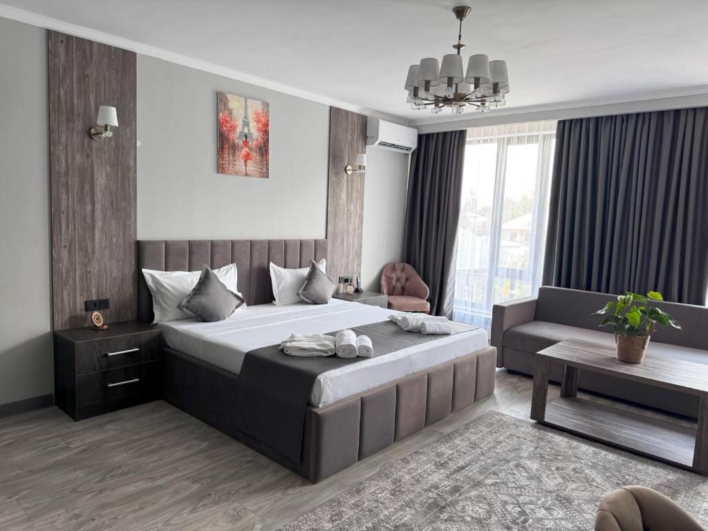 比什凯克Kausar Hotel的带一张大床和一张沙发的卧室