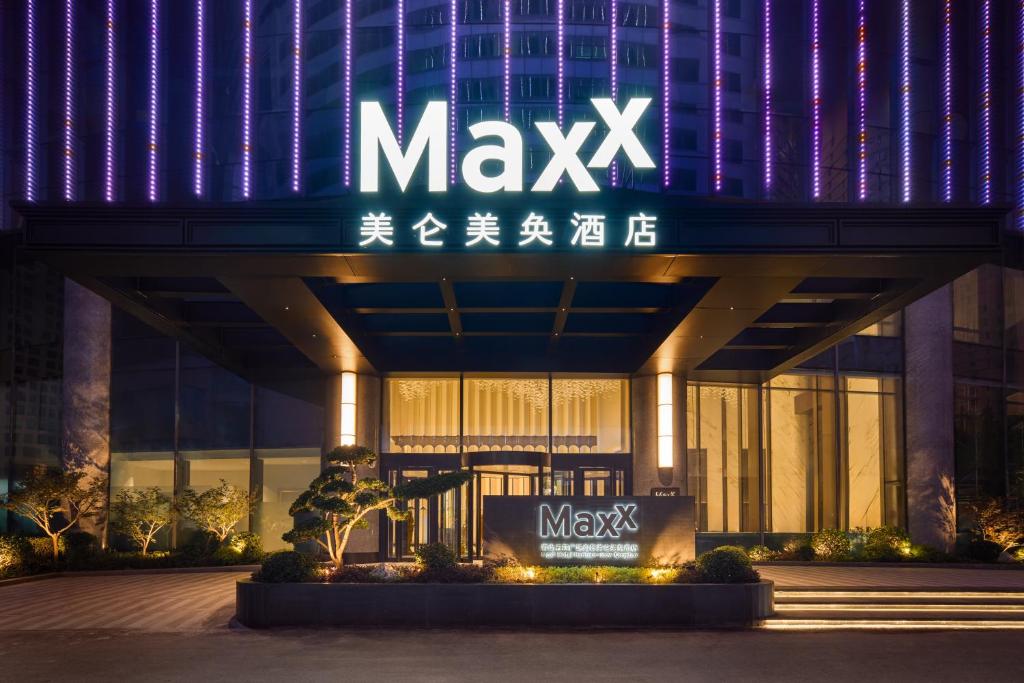 青岛MaxX by Steigenberger Harbour-view Qingdao的晚上有 macyx 标志的大楼