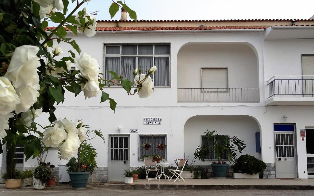 um edifício branco com flores em frente em Residencial Espadinha em Quarteira