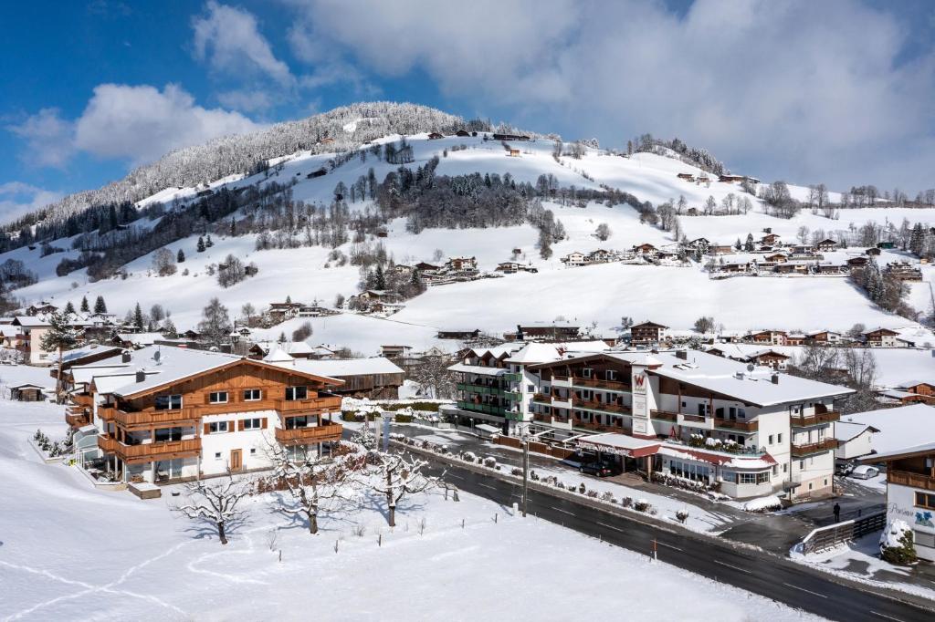a town covered in snow with a mountain in the background at Hotel Der Wastlhof - direkt an der Skipiste Wellness & Spa in Niederau