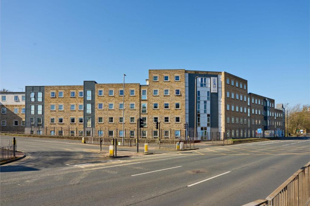 an empty street in front of a large brick building at For Students Only - Saw Mill in Huddersfield in Huddersfield