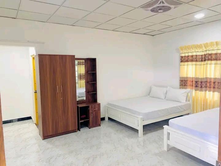 a bedroom with a bed and a cabinet in it at White Queen in Anuradhapura