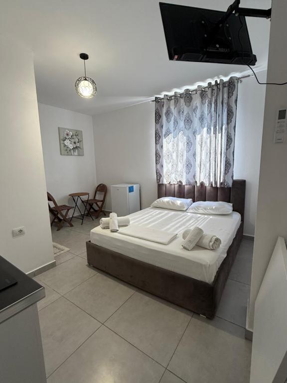 a bedroom with a bed and a television in it at Guest House Kloen in Vlorë