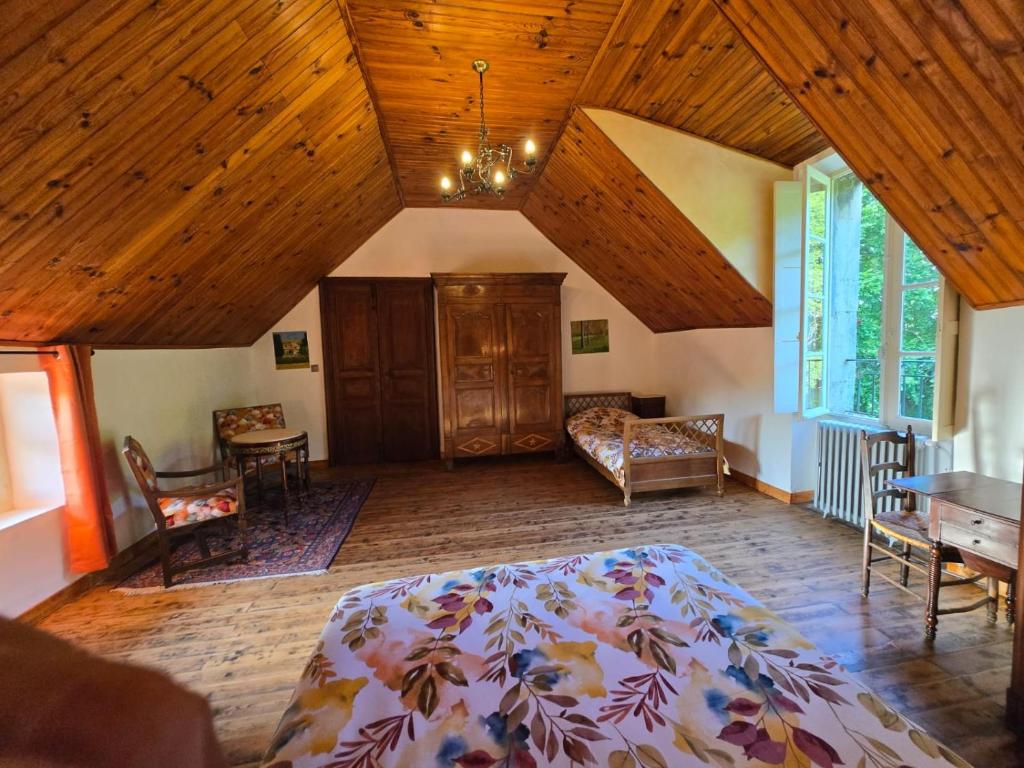 a bedroom with a large bed and a wooden ceiling at Château Rouge - petit château avec piscine - 8 chambres in Bollène
