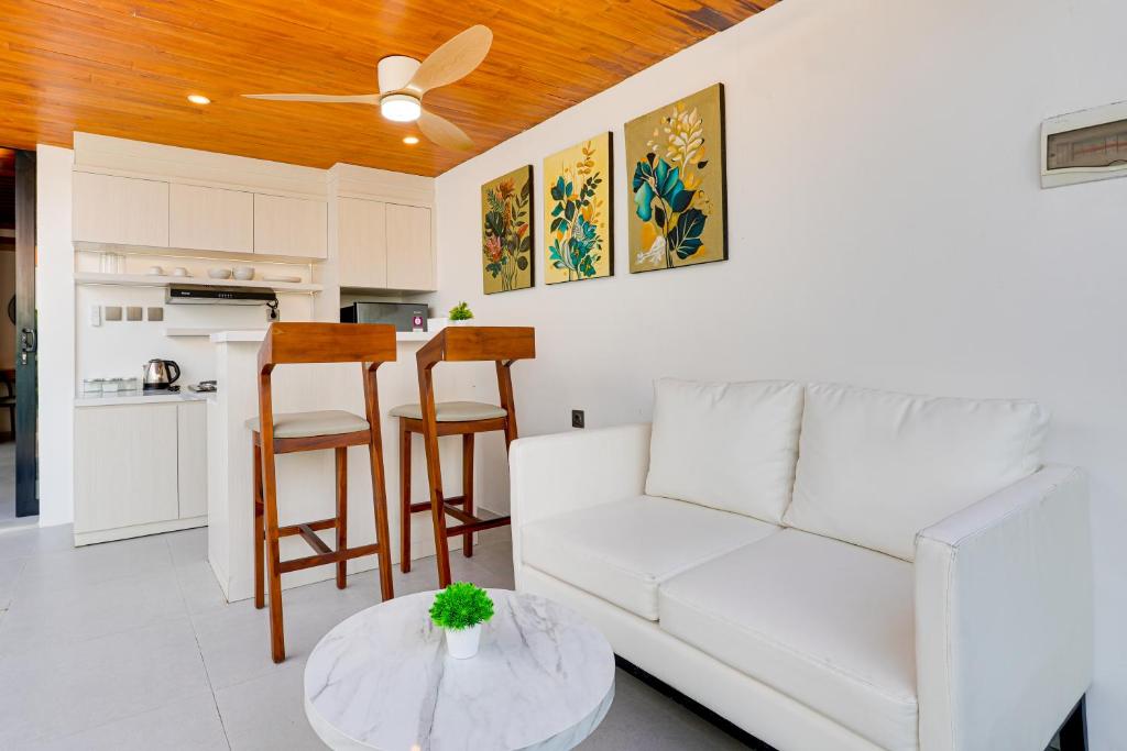 a living room with a white couch and a table at Cozy Honeymoon 1BR Villa Cempaka LaLuxe A9 Sanur in Sanur