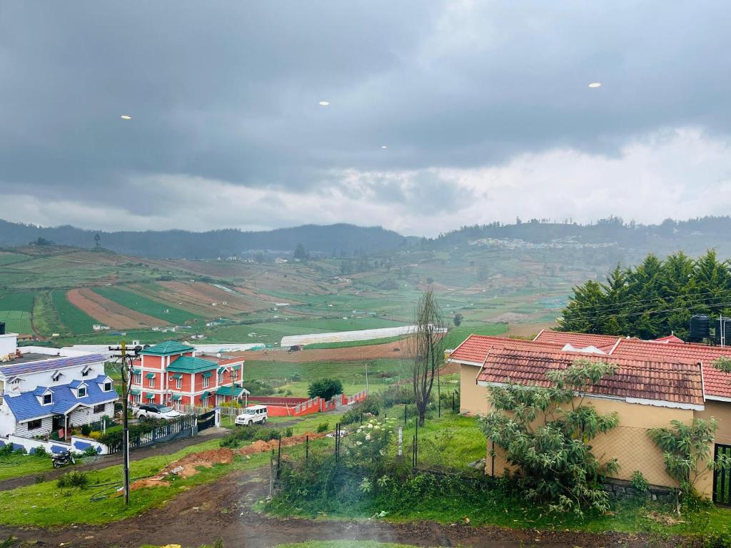 a view of a town with houses on a hill at Away From Home - 8 - HomeStay, Entire 2 BHK Villa in Ooty
