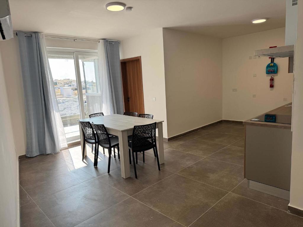 a kitchen and dining room with a table and chairs at Deluxe Apartment 2 Bed with Balcony - by HostMT in Taʼ Penza