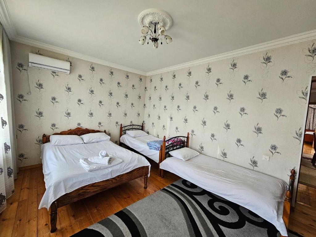 a bedroom with two beds and a chandelier at Big yard white villa AYT in Gabala