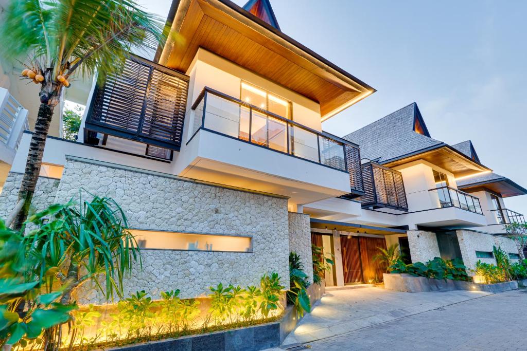 a house with a palm tree in front of it at NEW! Luxury Modern 3BR Villa Kesatu in Canggu in Canggu