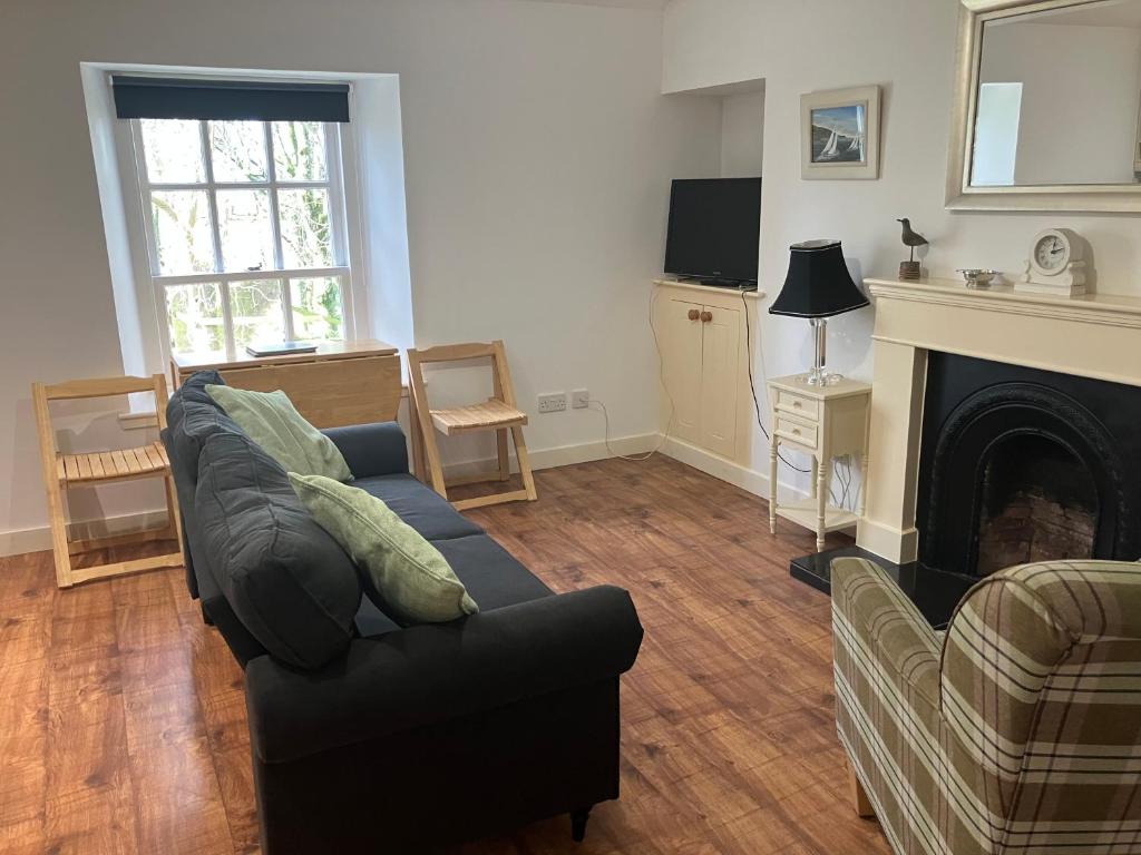 ein Wohnzimmer mit Couch und Kamin in der Unterkunft Berryhill Maids Quarters - 3 bedroom - Self Catering - Sleeps 3 - Dogs Welcome - Off-road Parking - Suit Contractors - Peterhead 1 mile - Newly Refurbished - Open plan kitchen -living - dining - 2 bathroom - Shed - Yard -Drying Room available in Peterhead