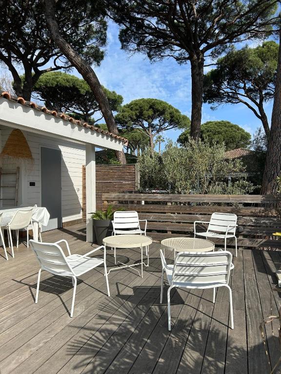 un groupe de chaises et de tables sur une terrasse dans l'établissement Charmante maison californienne - jacuzzi - piscine dans le domaine - Golfe de St Tropez - 6-8 personnes, à Gassin