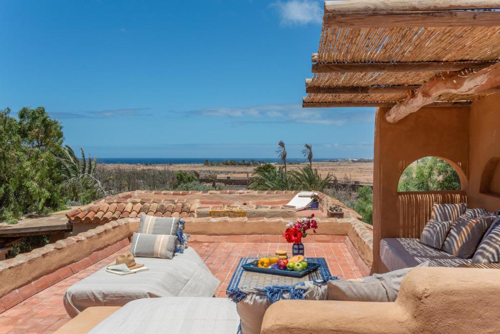 Un patio con muebles y vista al mar. en Oasis San Martin El Cotillo, en Playa del Águila