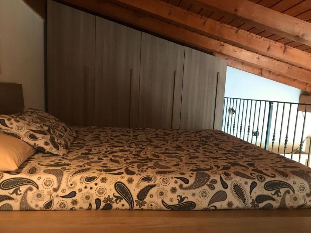 a bed in a bedroom with a large window at La casa rossa in Costa Volpino